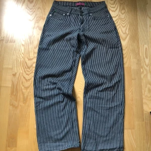 Baggy Low waist Jeans - Säljer dessa baggy lowrise jeans från danska märket Din Vintage Shop. Jeansen är blå och vit randiga (Se bild 3 för att se tydligt) modellen är Esther och i storlek S. Denna färgen säljs inte längre, sista bilden visar passformen men är i en annan färg. Dem är lite slitna längst ner där bak (bild 4) men annars i bra skick, nypris 631kr