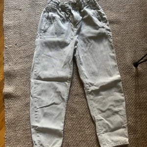 Beige byxor med hög midja från Zara - Snygga gröna byxor från Zara  och avslappnad passform. Byxorna har resår i midjan, dragkedja och knapp framtill samt sidfickor. Perfekta för en chill och trendig look.