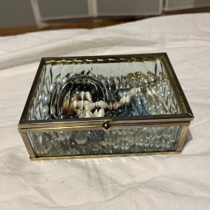 Mix av smycken i glasbox - Lite blandade smycken i både silver & guld. Nästintill allt i smyckeskrinet är oanvänt och även tvättade, och letar efter nya potentiella ägare🫶🏻 smyckeskrinet innehåller armband, halsband, örhängen och ringar. 