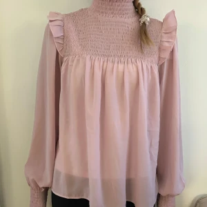 Rosa blus - Säljer en jättefin rosa blus från BikBok med fina volang axlar och lös passform. Storlek XS men passar förmodligen S/M!
