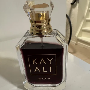 Kayali Vanilla | 28 parfym - Exklusiv parfym från Kayali, Vanilla | 28. Flaskan är elegant och kantig i genomskinligt glas med guldiga detaljer och en kristalliknande kork. Innehållet är mörkt bärnstensfärgat och flaskan har en lyxig känsla som sticker ut på hyllan. Ordinarie 50 ml, nu ca 40 ml