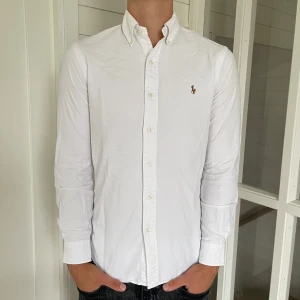 Polo Ralph lauren skjorta  - Säljer denna riktigt snygga vita Ralph lauren skjorta, den är i mycket bra skick utan några som helst defekter, storlek S modell slim fit den är 72 cm lång och 48 cm bred sitter riktigt bra på mig som är 183 cm lång, hör gärna av dig vid frågor!