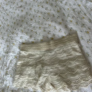 Beige virkade spets-shorts - Supersöta beige shorts med virkade spetsdetaljer och vågigt mönster. De är ganska lågmidjade och har en mjuk, elastisk midja. Perfekta för sommarens varma dagar och ger en romantisk, boho-vibe till din outfit. Shortsen har ett hål i spetsen undertill