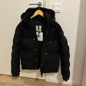 Moncler jacka - Säljer en varm vinterjacka från Moncler till ett superbra pris! Black label! Oanvänd alltså inga skador eller annat! Storlek 2/M men kan även passa dig som har L. Priset kan sänkas vid snabb affär! Skriv för mer info och intresse! 