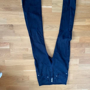 Svarta slim jeans med bootcut - Säljer ett par mörkblå jeans med smal passform med bootcut och klassisk femficksdesign. Jeansen har knappgylf.  Perfekta för dig som gillar en clean och stilren look.