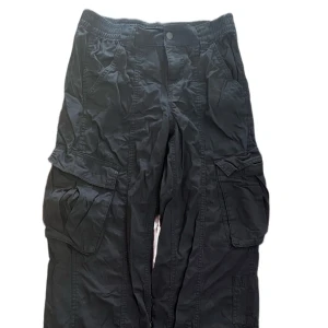 Svarta cargopants med resårmidja - 🌟Svarta cargopants med bred resår i midjan och stora fickor på sidorna. Byxorna har en loose passform och raka ben, perfekta för en avslappnad streetstil. Tillverkade i bomull för en skön känsla hela dagen. Använda max 2 gånger. Skickas snabbt!📦 