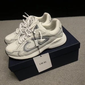 Vita Dior B30 sneakers - Hej, säljer mina Dior B30 Countdown Sneakers, men en unik reflex vid starkt ljus. Säljer dem då min farmor köpt fel typ av modell. Inte anvanda alls och är precis som nya. Alla tillbehör kommer med. Pris diskussion vid snabbaffär. För mer information hör gärna av er!