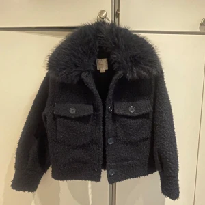 Blå teddyjacka från Gina Tricot (Young)  - Säljer min höst/vinter-jacka från föregående år. Upplever att den håller värmen bra. Sparsamt använd, nästintill oanvänd! Otroligt fin men numera för liten. Storleken är 146/152, jag är 17 år och 165cm lång och har inte växt ur den förrän nu. Inköpt för 499, säljs för 225kr! Köparen står för frakten! 