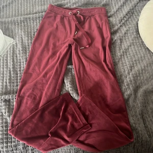 Vinröda mjukisbyxor med snörning - Mysiga vinröda mjukisbyxor med breda ben och snörning i midjan. Tillverkade i ett mjukt och skönt material som passar perfekt för chill dagar hemma eller när du vill vara bekväm. Snygg loose fit och enkel design.