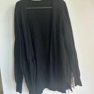 Cardigan  - Lång cardigan med liten slits på vardera sida. Klippt bort lappen i nacken då det klia 