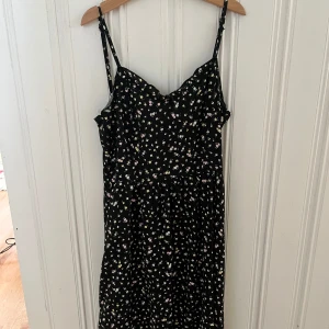 Svart blommig klänning - Svart blommig klänning från H&M, divided. Storlek 34. Mycket bra skick, knappt använd. 