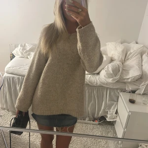 Beige stickad tröja - Mysig beige stickad tröja med avslappnad passform och långa ärmar. Perfekt för lager-på-lager och chill höst- eller vinterstil. Tröjan har en enkel design med ribbade muddar vid ärmslut och nederkant. Superenkel att matcha med jeans eller kjol.