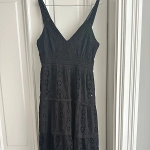 Svart långklänning i spets  - Supersöt svart långklänning från Fresh Cotton med broderade blommor och v-ringning. Strl S, men passar M