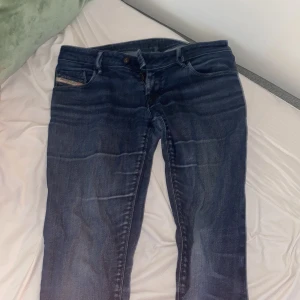Blå Diesel NEVY jeans  - Säljer ett par snygga blå Diesel NEVY jeans med klassisk femficksdesign och diskret tvättad look. Jeansen har stretch för extra komfort och en rak passform. Märkesdetalj på myntfickan och coola slitningar längs benen.