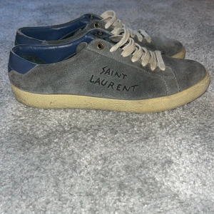 Ljusblå mocka Saint Laurent sneakers - Tja! Säljer mina ljusblå Ysl skor i str 39 men sitter mer som små 40! Skorna e ganska slitna då mockan e väldigt sliten och att det är hål vid både hälarna bild 2 går säkert att fixa hos en skomakare och mockan är ganska mycket borta men med en mockaborste hjälper det lite! Används väldigt mycket som ni kan se men är fortfarande väldigt feta! Har ej kvitto eller box men köptes på Plick för runt 3000kr föra året i maj och nypris är runt 6000kr skriv om ni har några fler frågor mvh Arvid!