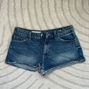 Blå jeansshorts  - Klassiska blå jeansshorts med fem fickor, bälteshällor. Stolek 38 men känns som 36/34
