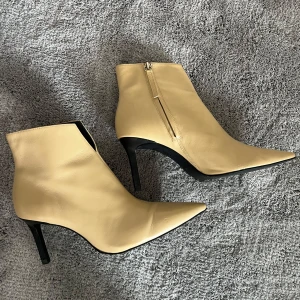 ZARA stövletter  - Snygga beige stövletter i skinn med spetsig tå och smal hög klack på 5 cm. Dragkedja på sidan för enkel påtagning. Perfekta för dig som vill ha en stilren och trendig look med edge för hösten! Använd endast en gång men är i helt ny skick. Ursp. Pris låg på 1295 kr. 
