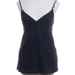 Abercrombie babydoll topp - Snygg mörkblå linnetopp med smala, flätade axelband och v-ringad omlott framtill. Perfekt för varma dagar och enkel att matcha med jeans eller kjol. Lätt och luftig känsla.