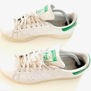 Adidas Stan Smith vita sneakers - Klassiska Adidas Stan Smith sneakers i en tidlös vit och grön färgkombination. Perfekt för en avslappnad och stilren look. Ett ikoniskt val för alla tillfällen.  Passar män och kvinnor. ordpris: 1149kr Bilderna togs personligen av mig, vilket säkerställer att du ser exakt den produkt du köper.Vänligen observera att jag inte har någon öppetköp.Skickar endast med PostNord.