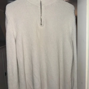 Beige stickad tröja med dragkedja Zara - Säljer en beige stickad tröja från Zara i storlek M. Tröjan har en hög krage och en snygg dragkedja framtill. Perfekt för lager-på-lager och chill höst- eller vinterstil. Ribbstickad struktur och långärmad modell för extra mysfaktor.