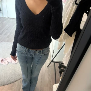 Marinblå stickad tröja från Zara - Mysig stickad tröja från Zara med kabelstickat mönster och v-ringad hals. Otroligt skön och snygg, passar till allt! Använd fåtalgånger. Väldigt stilren.