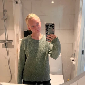 Grön stickad tröja från Vero Moda - Mysig grön stickad tröja från Vero Moda med rund halsringning och ribbade muddar. Perfekt för lager-på-lager och chill dagar. Långärmad och i klassisk, enkel modell som funkar till allt.