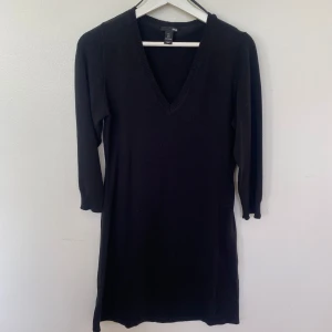 Svart stickad klänning från H&M - En svart stickad klänning från H&M i storlek L. Klänningen har v-ringning, trekvartsärm och en rak, enkel passform. Använd fåtal gånger.