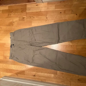 Beige chinos från H&M relaxed fit - Helt oanvända snygga beige chinos från H&M i relaxed fit. Byxorna har klassisk rak passform med knapp och dragkedja i midjan. Perfekta för en chill och stilren look, tillverkade i mjukt bomullsmaterial.