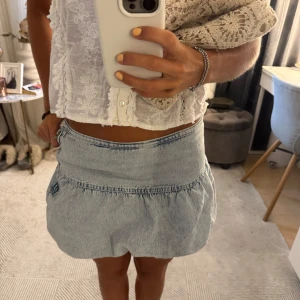 Ljusblå jeanskjol med volang - Supersöt ljusblå jeanskjol med volangkant och ballongformad nederdel med dragkedja på sidan. Perfekt för dig som vill ha en chill och trendig look till sommaren.