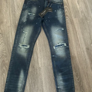 Supply & Demand Jeans - Snygga blå jeans från Supply & Demand med slitna detaljer och blekta partier framtill. Jeansen har klassisk femficksdesign och är tillverkade i stretchig denim för en tight passform. Perfekta för dig som gillar en trendig och urban look.