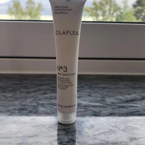 Olaplex No.3 Hair Perfector 20ml - Olaplex No.3 Hair Perfector i en smidig vit tub på 20 ml. Denna produkt stärker och reparerar alla hårtyper och är perfekt att ha med på resan. Tuben är gjord av plast och har svart text. En riktig klassiker för dig som vill boosta håret.