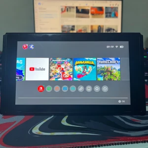Nintendo switch  - Bilderna visar en Nintendo Switch-spelkonsol med populära spel som Mario Kart 8 Deluxe, Brawlhalla och Minecraft. Konsolen är portabel och perfekt för gaming på språng eller hemma. Skärmen och baksidan syns tydligt, och den verkar vara i gott skick – redo för nya äventyr!