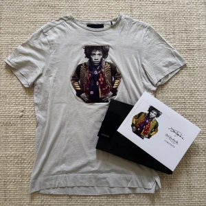 Vit t-shirt med konstmotiv från Limitato - Ljusgrå Limitato Jimi Hendrix t shirt, limited edition. Storlek M, och den är i mycket bra skick! Inga defekter finns. Box och allt OG medföljer!