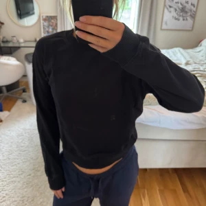 Svart sweatshirt från NA-KD - En basic svart sweatshirt från NA-KD med rund halsringning och långa ärmar. Tröjan har ribbade muddar vid ärmslut och nederkant, och är i mjuk bomull. 