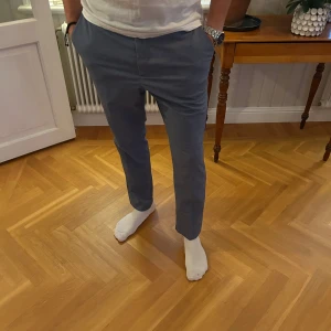 Kostymbyxor - Snygga blå kostymbyxor med rak passform. Lite ljusare i färgen men sjukt trevliga till en vit tröja. Modell är 183cm & 75kg. Bara att skriva om ni undrar något!