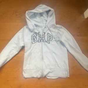 Light blue GAP hoodie - Light Blue GAP Hoodie (Size S) Soft and comfy GAP hoodie in light blue. It has a zipper in the front, a hood with strings, and big GAP letters on the chest. Inside is warm and soft. Size small. Good condition!