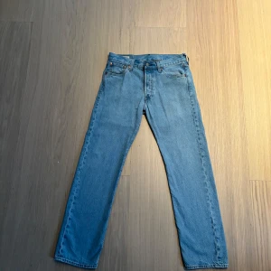 Levi's 501 ljusblå jeans 30/30 - Klassiska Levi's 501 jeans i ljusblå denim. Rak passform med knappgylf, fem fickor och ikonisk läderpatch bak i midjan. Perfekta vintage-vibbar och snyggt slitna detaljer. Passar dig som gillar tidlös stil och vill ha ett par riktigt schyssta jeans. De är använda men har inga synliga defekter. Skriv till mig vid funderingar och kolla in mina andra annonser! Rabatt tillkommer vid köp av bundles! 