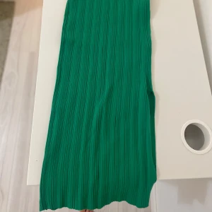 Grön ribbad kjol från MNG - Snygg grön ribbad kjol från MNG i storlek S. Den är lång om man har den som kjol men kan även användas som klänning. Jag har bara tröttnat på färgen, den har använts kanske 5 gånger.