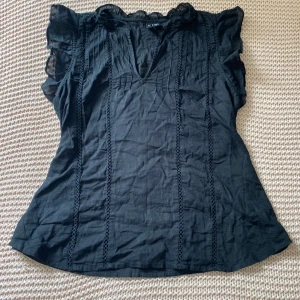 Svart blus med volangärm Vero Moda XS - Svart blus från Vero Moda i luftig bomull med v-ringning, volangärmar och dekorativa spetsdetaljer längs framsidan. Nypris 325kr. Blusen har en lätt transparent känsla och är perfekt för dig som gillar en feminin och trendig stil. Använd en gång💞 väldigt skrynklig på bilderna jag ber om ursäkt för de❤️