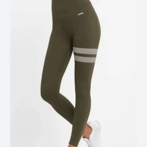 Gröna Stronger leggings med ränder - Snygga gröna leggings från Stronger med två vita, reflekterande ränder runt ena låret. Hög midja och tight passform, perfekta för träning eller att bara vara hemma! Använd cirka 3-4 gånger finns inga tecken på användning storlek xs men passar mig med storleken s 