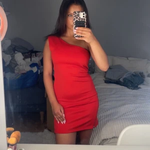 Röd one shoulder klänning - Snygg röd kortklänning från Bik Bok i one shoulder-modell. Klänningen är tight och har en dragkedja längs nederkanten på sidan. Dm:a vid frågor eller funderingar!💕