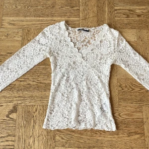 Vit spetsblus med v-ringning - Säljer en superfin vit blus från Gina Tricot i  spets med v-ringning och långa ärmar. Använd en gång på konsert. Köpte för 300 och säljer för 200 kr men priset kan diskuteras.