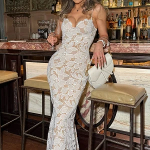 Vit spetsklänning med blommönster - Supersnygg långklänning i vit spets med stora blommor och figurnära passform. Klänningen har smala axelband, v-ringad byst och transparenta partier som ger en lyxig känsla. Perfekt för dig som vill sticka ut på festen!