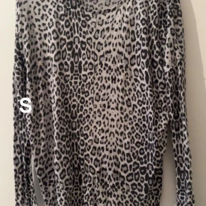 Leopardmönstrad långärmad tröja S - Snygg långärmad tröja med svart och grått leopardmönster. Perfekt för dig som vill sticka ut lite extra. Mjuk och skön, passar till både jeans och kjol. Rund halsringning och normal passform.🌸Fint använt skick. Storlek s 