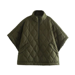 Olivgrön quiltad pufferjacka - Quiltad pufferjacka i olivgrönt med hög krage och half zip-dragkedja. Jackan har korta, vida ärmar och två snedställda fickor med knappstängning. Perfekt för lager-på-lager och chill höst- eller vinterstil. Står ej märke! Priset är diskuterbart!