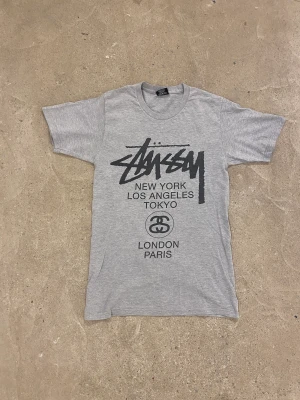 Stussy T-shirt  -  Fet Stussy t-shirt. Extremt sällsynt modell där det står alla städer Stüssy har butiker på ryggen. mycket bra skick utöver två små hål och pyttelite nopprig Frågor? Kontakta mig✅ Allt gott, Noah