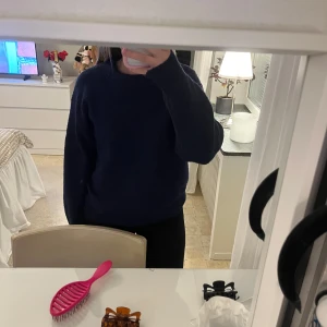 Mörkblå stickad tröja  - Mysig mörkblå stickad tröja med rund halsringning och ribbade muddar. Tröjan har en loose passform och långa ärmar, perfekt för lager-på-lager. Tröjan är nopprig och har även ett litet hål på baksidan, inget jag tänkt på. Köpt på gina young, storlek 158/164 men sitter som en S