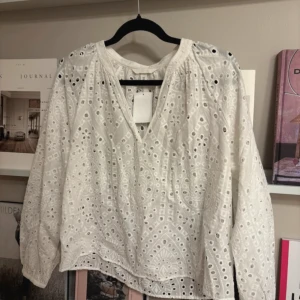 Vit blus med broderi - Jätte fin långärmad blus med broderi. Helt ny med prislapp