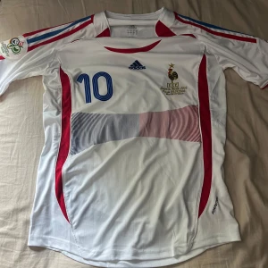 Fotbollströja Frankrike 2006 ZIDANE 10 - En sällsynt klassiker från 2006 känd som tröjan zidane gjorde sin pannenka och blev utvisad för en skallning. Tröjan är ny inköpt och ny pris för original är upp mot 3000kr
