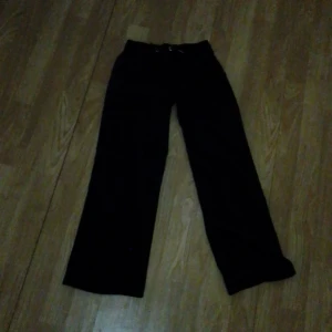 Mörkblåa juicy byxor - Mörkblåa juicy byxor som är snygga men en knapp på röven och de e riktiga juicy och den är märk makerad på sidan